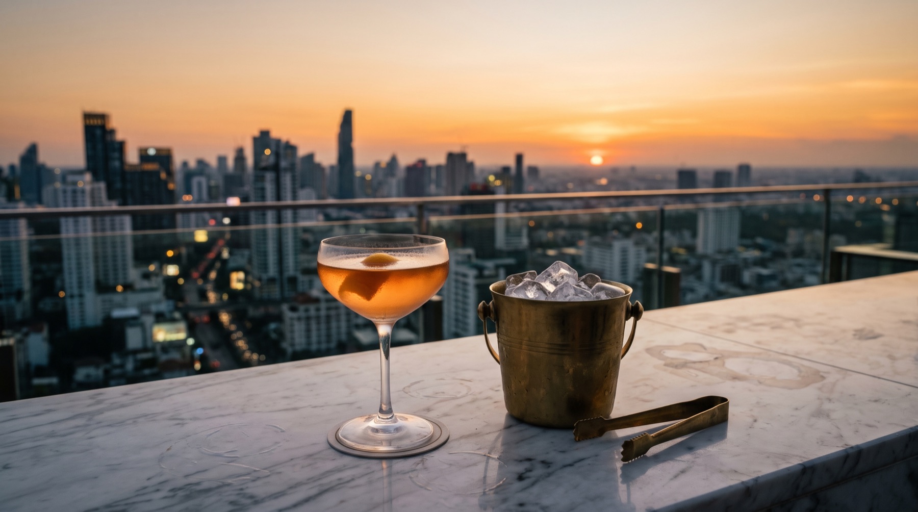 Cocktail und Eiskübel auf einer Marmortheke über der Stadt bei Sonnenuntergang (Bild mit KI erstellt)